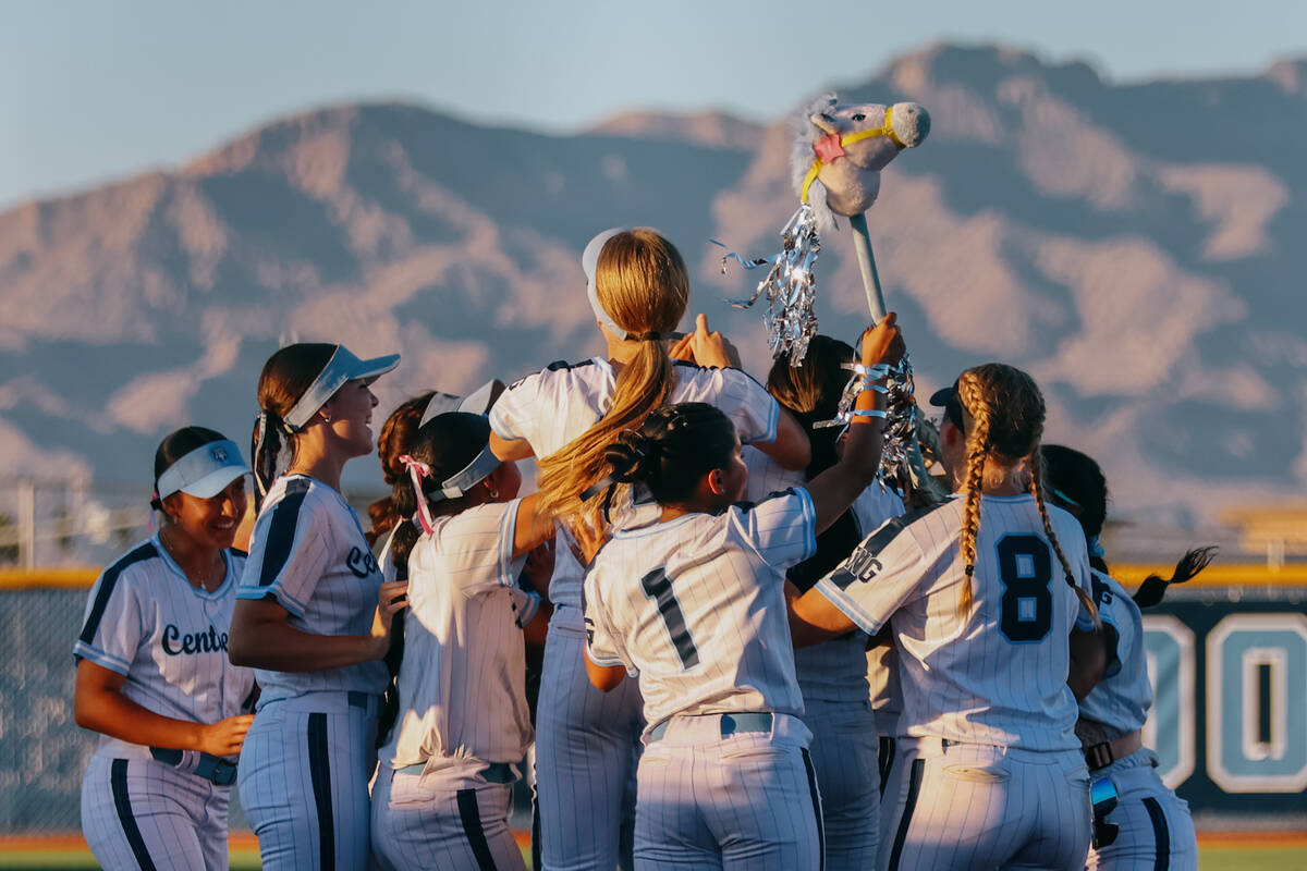 Centennial softball players jump up and down with a toy horse after winning the NIAA 5A Souther ...