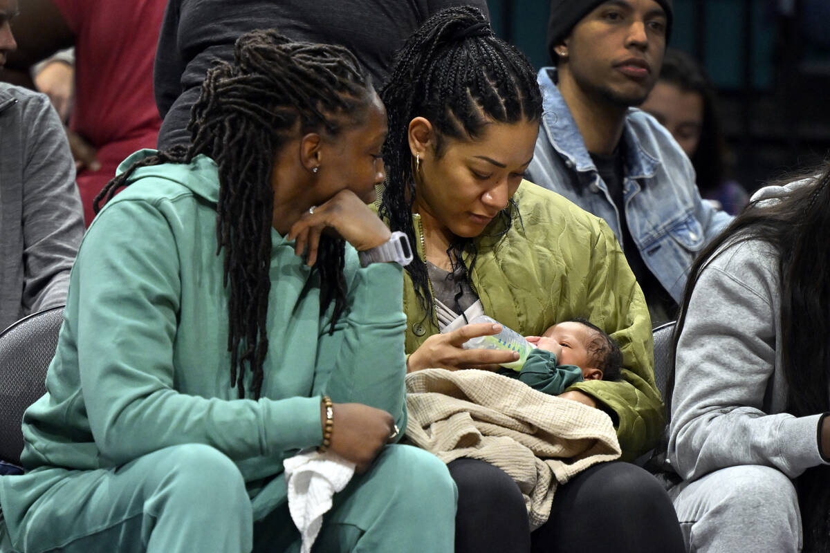 Chelsea Gray of the Aces, left, and her wife, Tipesa Gray, look at their newborn son, Lennox, d ...