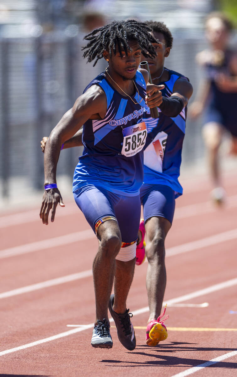 Canyon Springs' De'Andre Jenkins (5852) takes the baton from his teammate on the way to winning ...