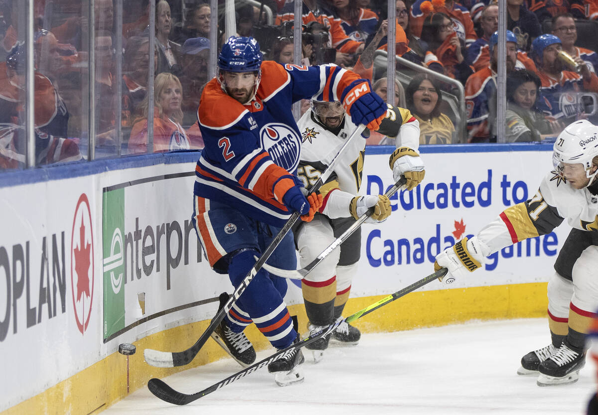Vegas Golden Knights' Keegan Kolesar (55) and Edmonton Oilers' Evan Bouchard (2) battle for the ...