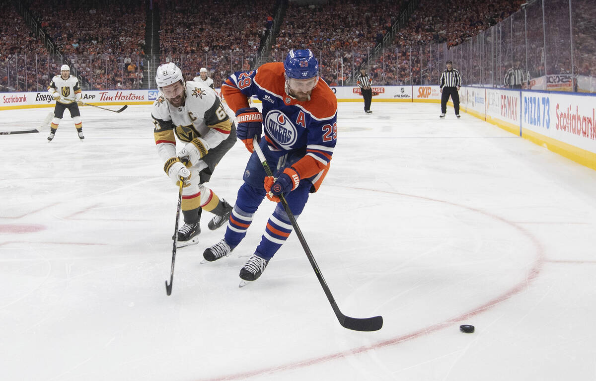 Vegas Golden Knights' Mark Stone (61) and Edmonton Oilers' Leon Draisaitl (29) battle for the p ...