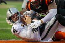 Raiders quarterback Derek Carr (4) holds on to the football as he is sacked by Cincinnati Benga ...