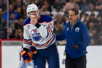 Edmonton Oilers center Trent Frederic (21) is escorted after a stick to the face by Golden Knig ...