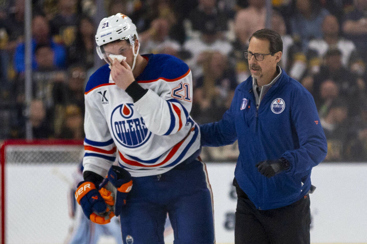 Edmonton Oilers center Trent Frederic (21) is escorted after a stick to the face by Golden Knig ...