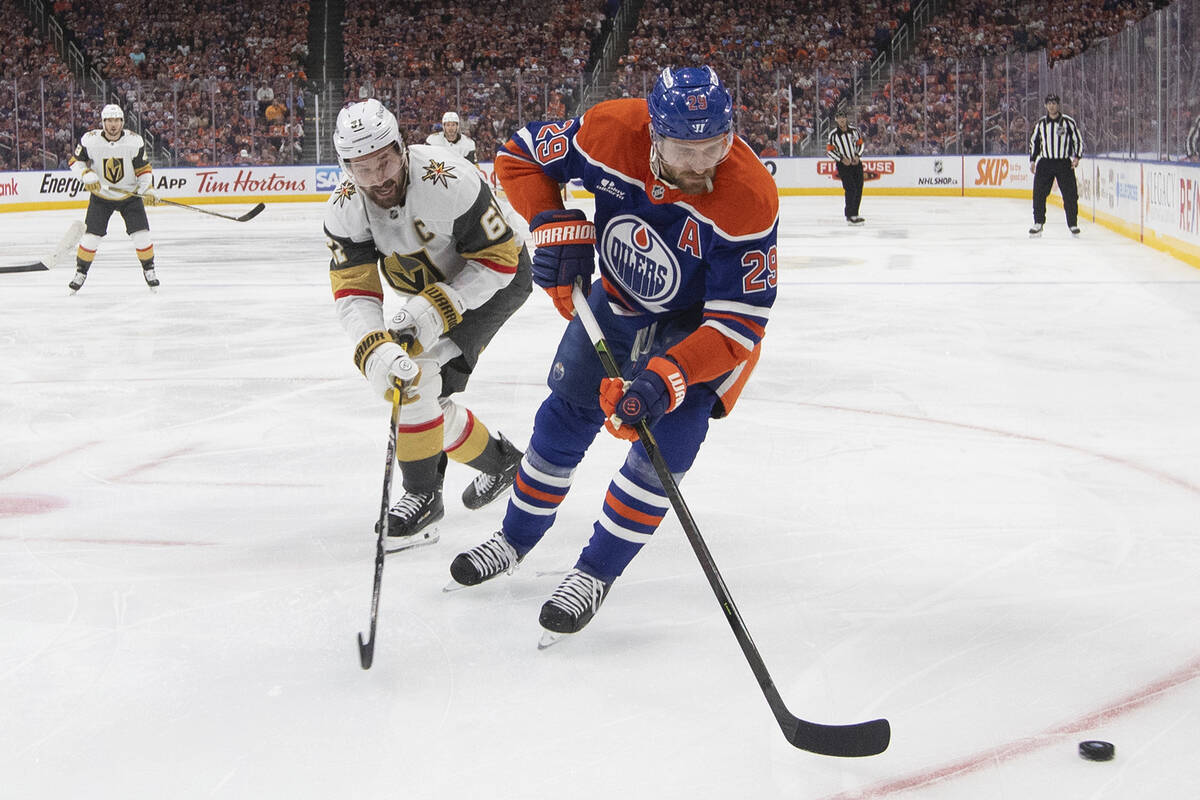 Vegas Golden Knights' Mark Stone (61) and Edmonton Oilers' Leon Draisaitl (29) battle for the p ...