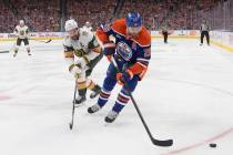 Vegas Golden Knights' Mark Stone (61) and Edmonton Oilers' Leon Draisaitl (29) battle for the p ...