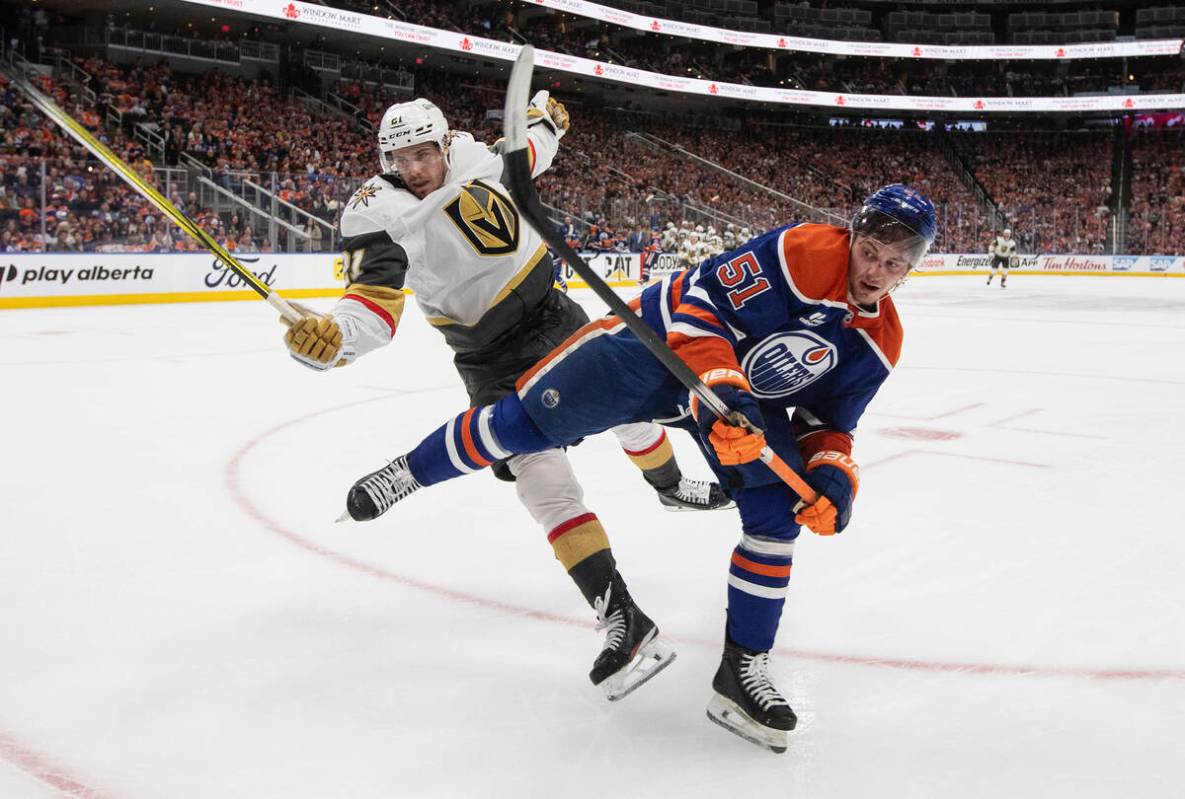 Vegas Golden Knights' Brett Howden (21) is checked by Edmonton Oilers' Troy Stecher (51) during ...
