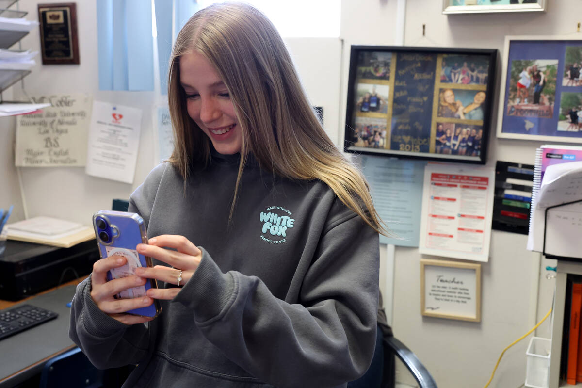Hillside Hotwire staff writer Caysea Winn takes a photo of her award during Journalism Foundati ...
