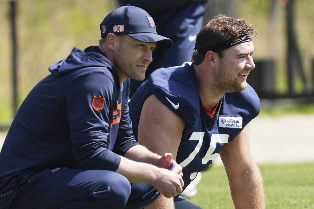 Chicago Bears head coach Ben Johnson, left, and offensive line Ozzy Trapilo watch during the NF ...