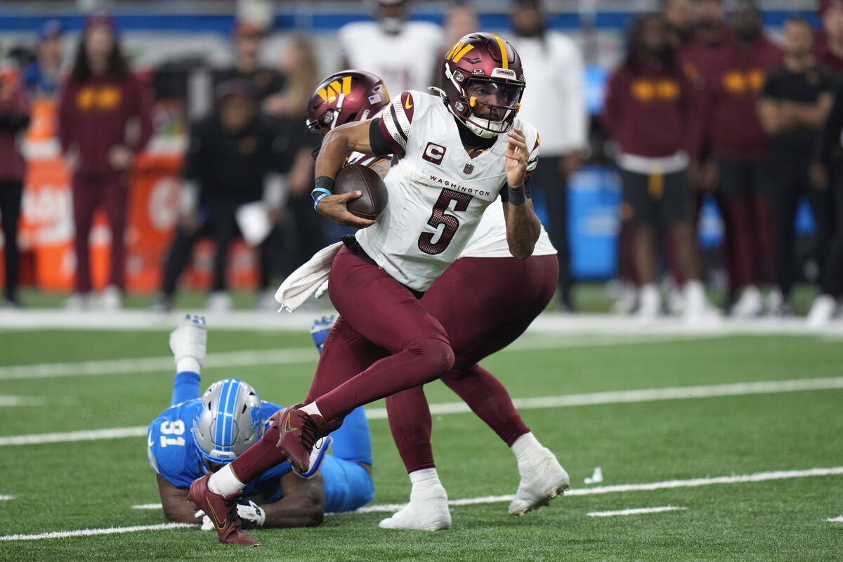 Washington Commanders quarterback Jayden Daniels (5) runs the ball past Detroit Lions defensive ...