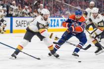 Vegas Golden Knights' Mark Stone (61) and Edmonton Oilers' Leon Draisaitl (29) battle for the p ...
