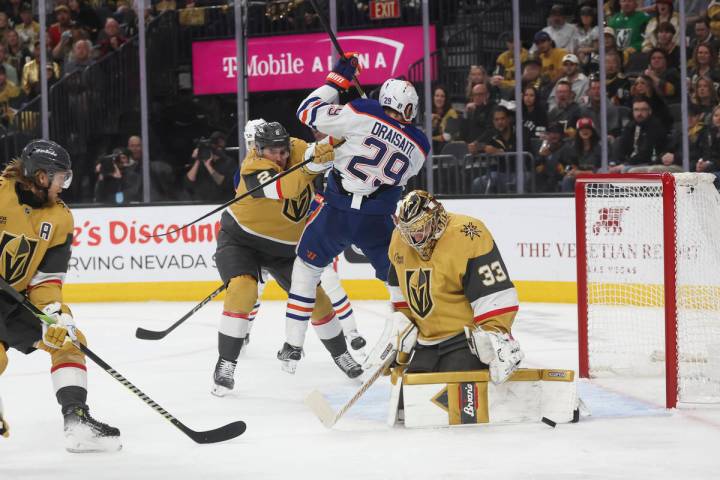Golden Knights goaltender Adin Hill (33) deflects the puck as Golden Knights defenseman Zach Wh ...