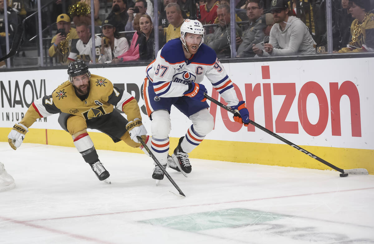 Edmonton Oilers center Connor McDavid (97) skates with the puck under pressure from Golden Knig ...