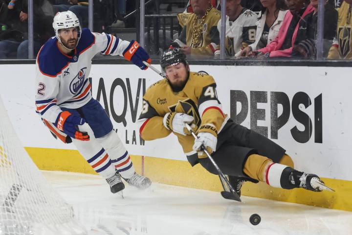 Golden Knights center Ivan Barbashev (49) gets tripped by Edmonton Oilers defenseman Evan Bouch ...