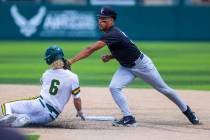 Faith Lutheran infielder Rouselle Shepard (5) tags out a sliding Bishop Manogue runner Cinco Gu ...