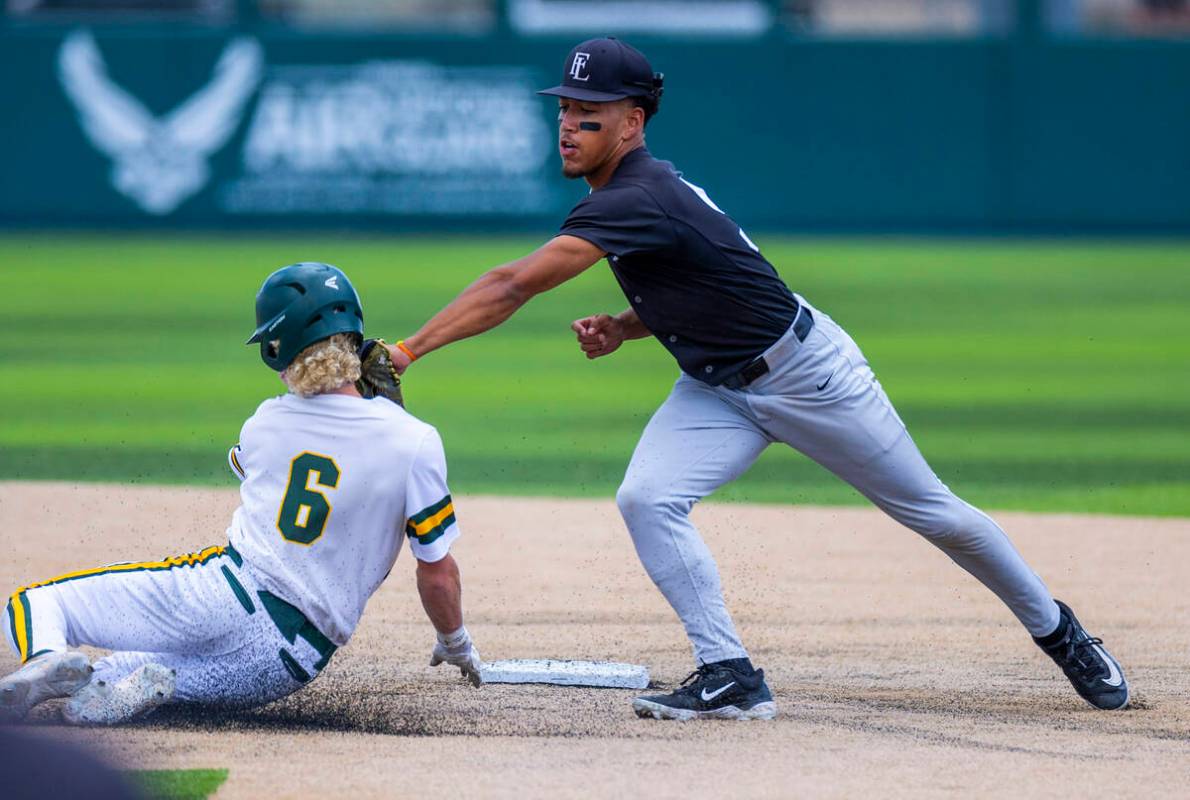 Faith Lutheran infielder Rouselle Shepard (5) tags out a sliding Bishop Manogue runner Cinco Gu ...