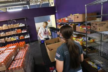 Volunteers Sara Ricciardi and her daughter Grace, 16, of Henderson, move food pantry items for ...