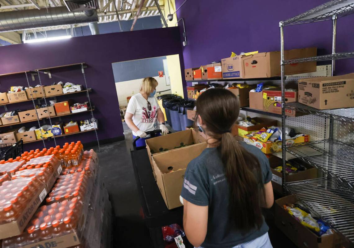 Volunteers Sara Ricciardi and her daughter Grace, 16, of Henderson, move food pantry items for ...
