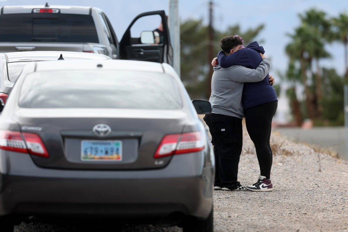 People comfort each other following an officer involved shooting that left a suspect dead at La ...