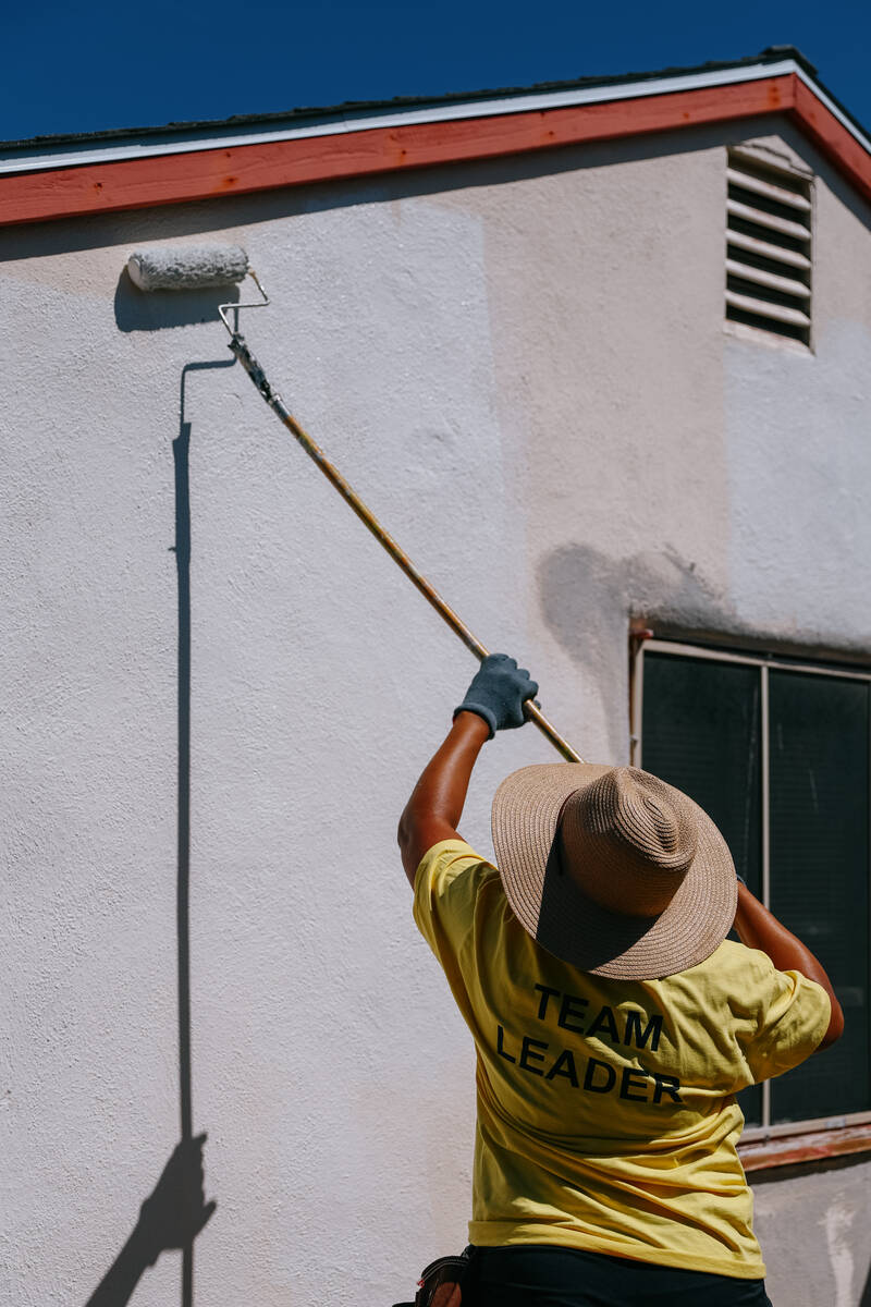 Realtor Nicole Hollimon applies a fresh coat of white paint to a home while volunteering with L ...