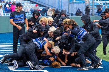 Basic players celebrate their extra-inning win against Reno to take the championship of the 5A ...