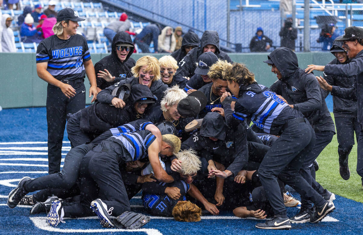 Basic players celebrate their extra-inning win against Reno to take the championship of the 5A ...