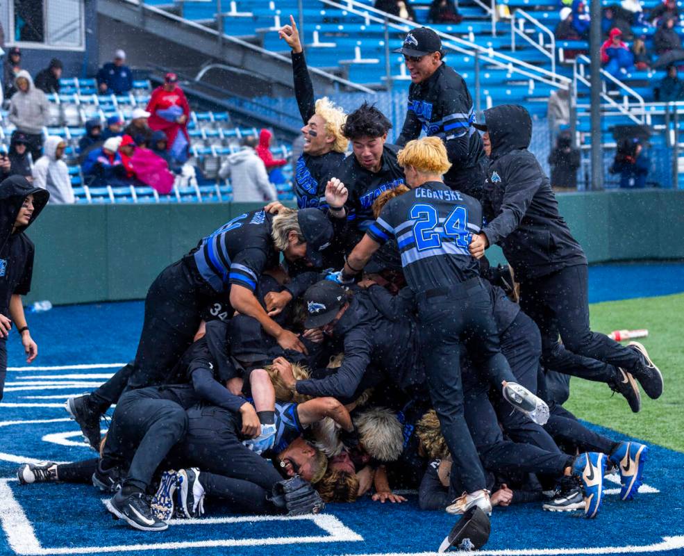 Basic players celebrate their extra-inning win against Reno to take the championship of the 5A ...