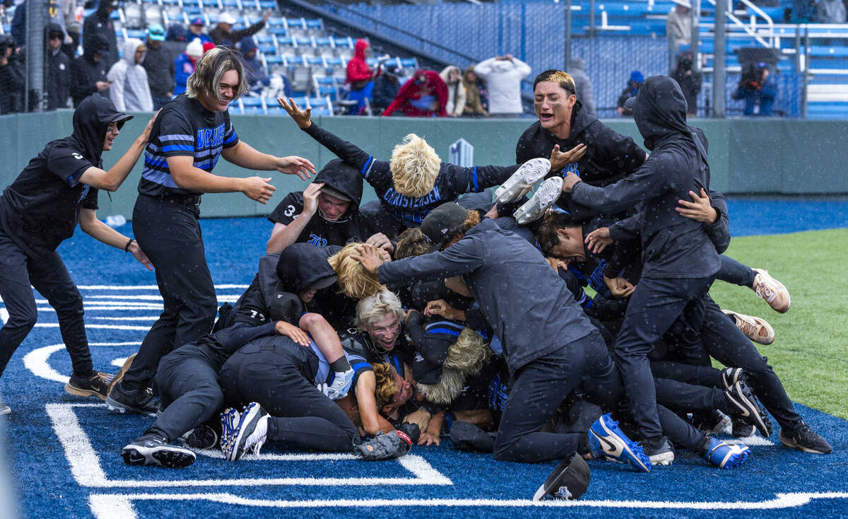 Basic players celebrate their extra-inning win against Reno to take the championship of the 5A ...