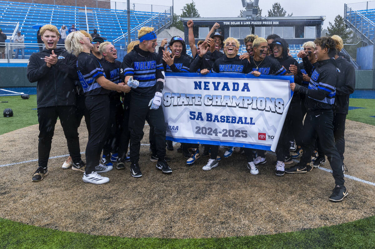 Basic players celebrate their extra-inning win against Reno to take the championship of the 5A ...