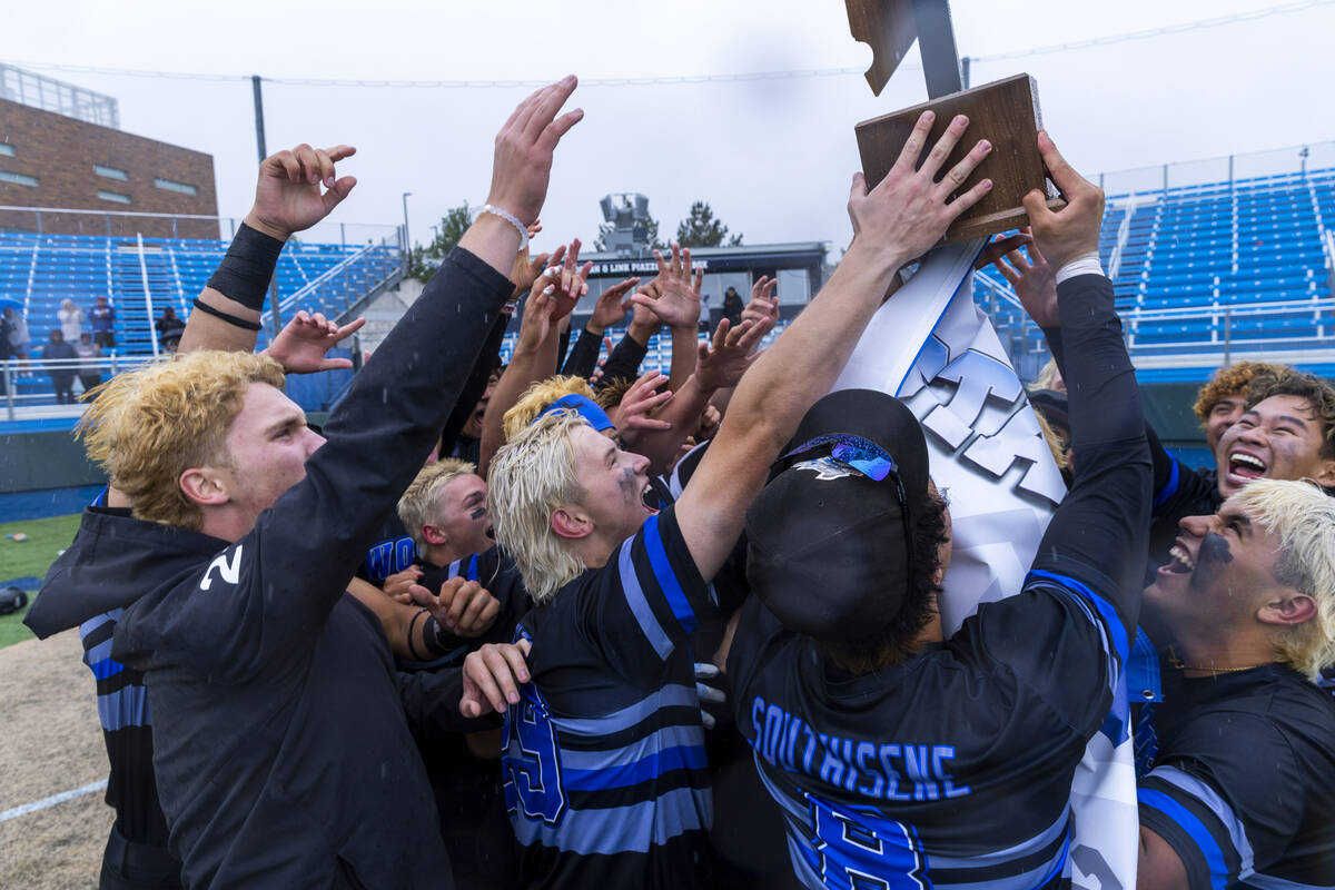 Basic players celebrate their extra-inning win against Reno with the trophy taking the champion ...