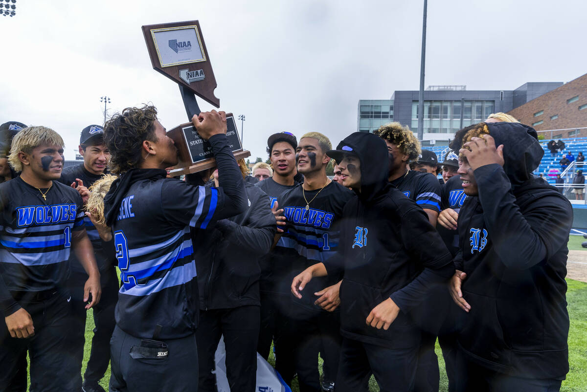 Basic's Tate Southisene (2) kisses the trophy as he and teammates celebrate their extra-inning ...