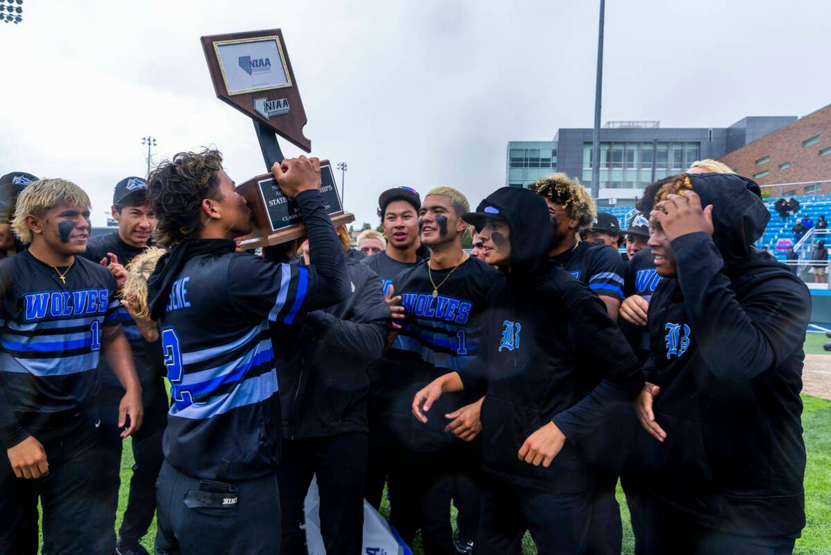 Basic's Tate Southisene (2) kisses the trophy as he and teammates celebrate their extra-inning ...