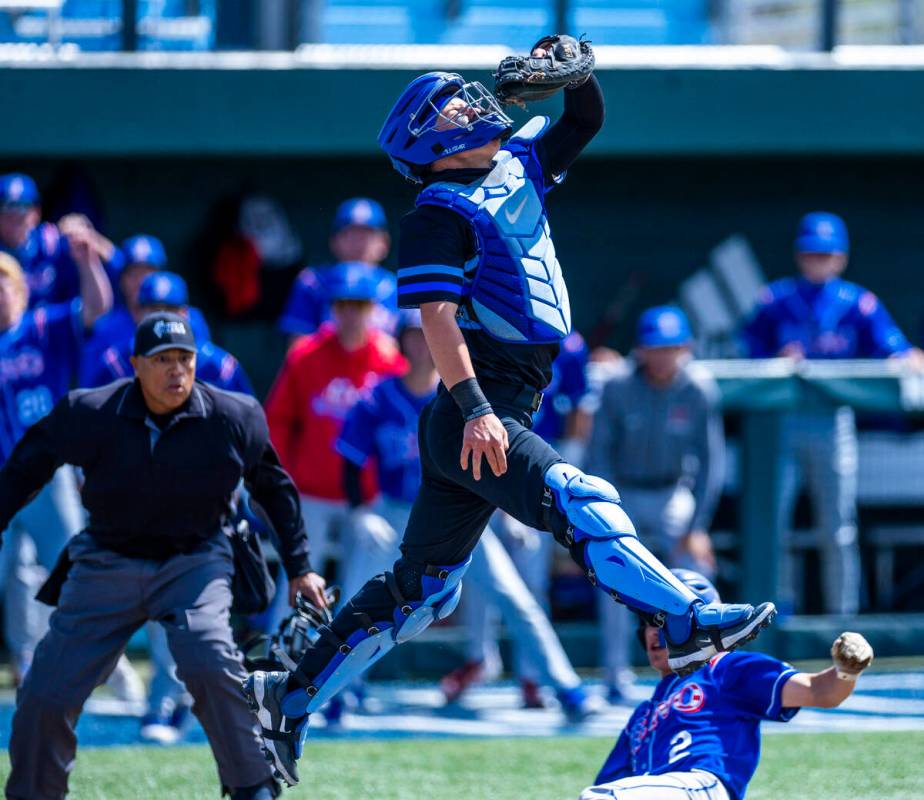 Basic catcher Koa Won (4) elevates to grab a wild throw as Reno runner Braden Jones (2) slides ...