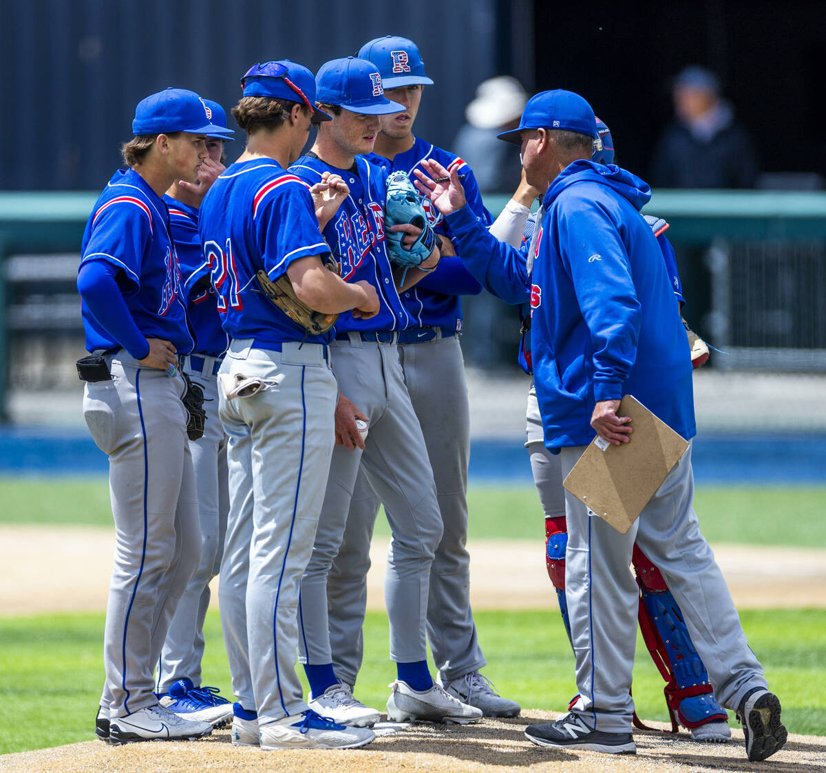 Reno head coach Pete Savage counsels his infielders on the mound on a timeout against Basic dur ...