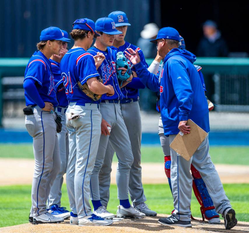 Reno head coach Pete Savage counsels his infielders on the mound on a timeout against Basic dur ...