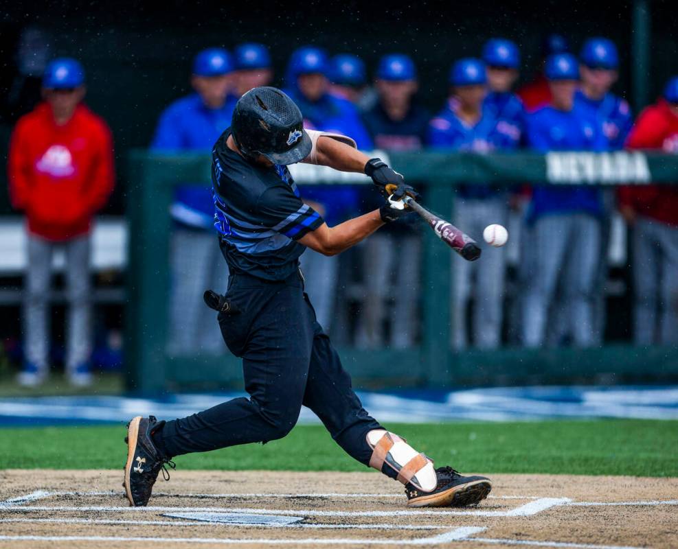 Basic batter Lyndon Lee (15) connects with a Reno pitch in the rain in extra innings during the ...