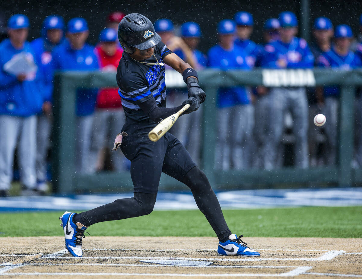 Basic batter Ace Sapp (5) connects with a Reno pitch in the rain loading the bases in extra inn ...