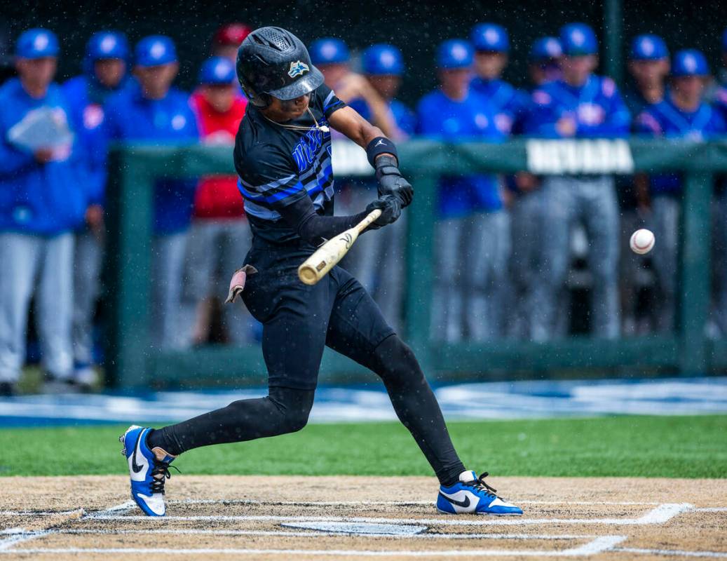Basic batter Ace Sapp (5) connects with a Reno pitch in the rain loading the bases in extra inn ...