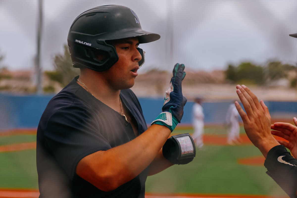 Silverado’s Giovanni Guariglia (3) high fives teammates after earning a run for the Skyh ...