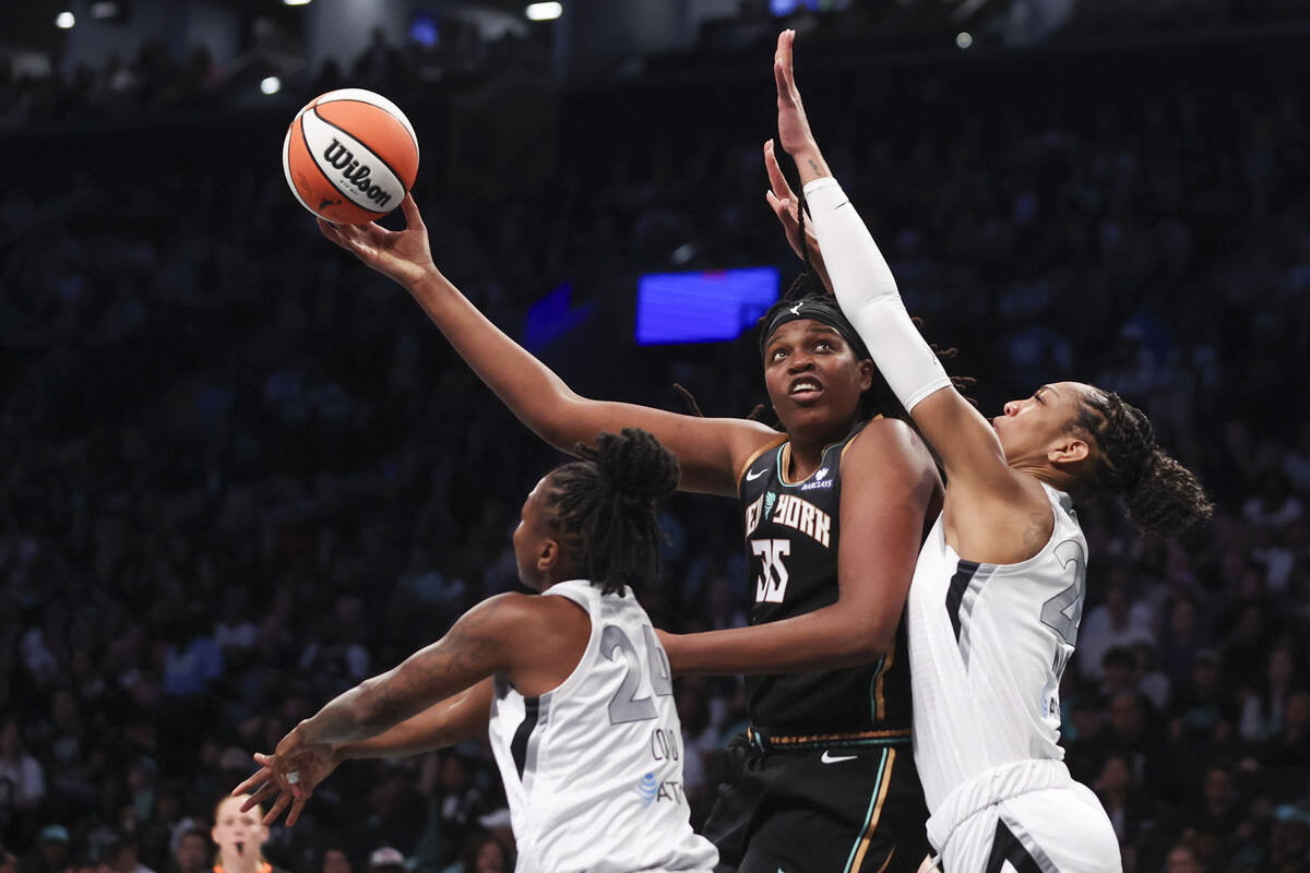 New York Liberty center Jonquel Jones (35) shoots as Las Vegas Aces guard Jewell Loyd (24) and ...