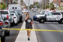 A bystander walks on Rainbow Boulevard as Las Vegas police investigate following an officer inv ...