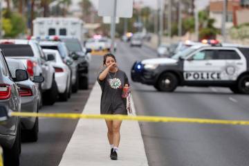 A bystander walks on Rainbow Boulevard as Las Vegas police investigate following an officer inv ...