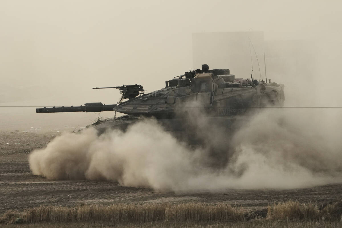 An Israeli tank moves in a staging area in southern Israel, near the border with Gaza, Friday, ...