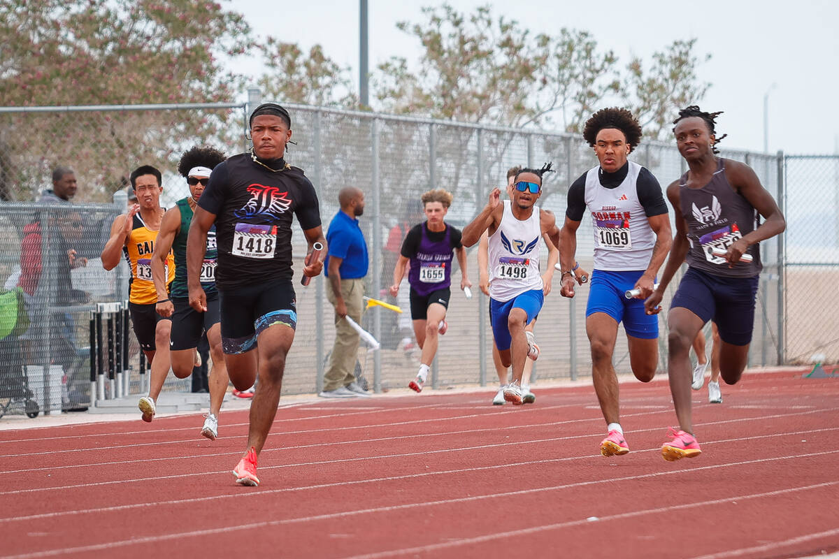 Runners race towards the finish line on the last leg of the NIAA 5A Boys 4x100-meter relay fi ...