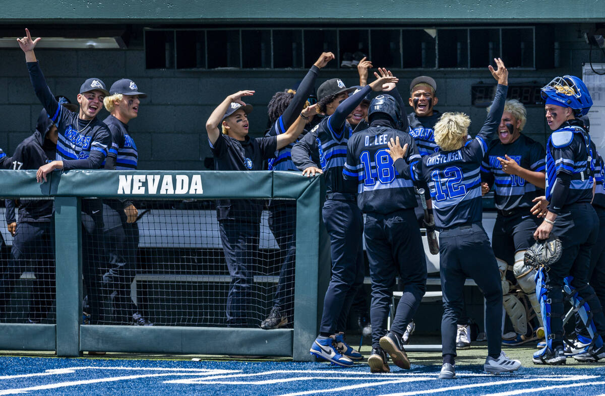 Basic players celebrate a tying run by Dillon Lee (18) against Reno during the final of the 5A ...