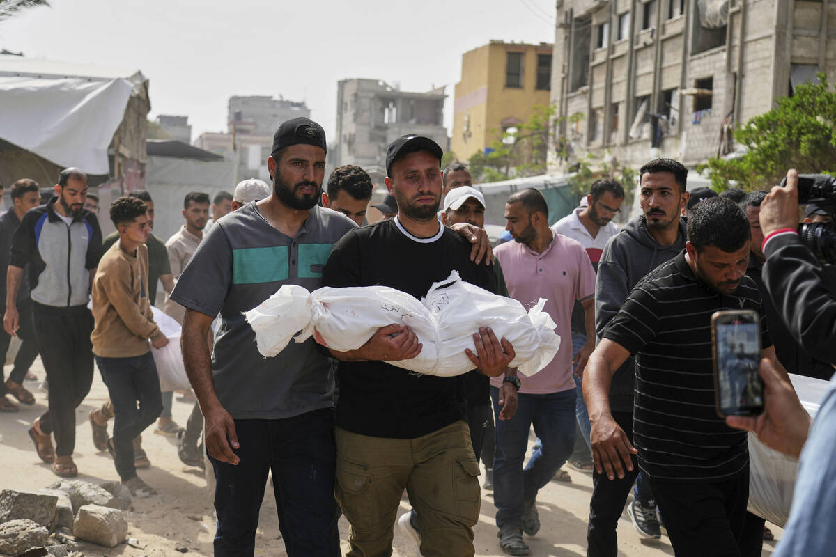 Saleh Zenati, carries the body of his infant nephew Khalid Zenati killed in an Israeli army air ...