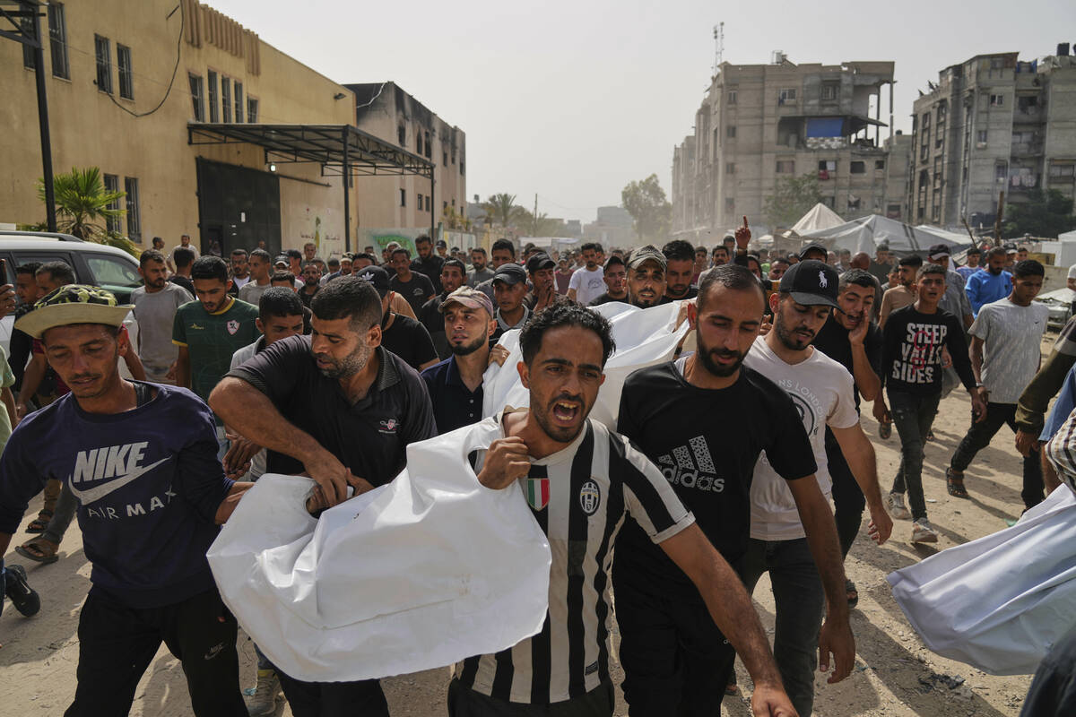 Palestinians carry the bodies of their relatives killed in an Israeli army airstrike, during th ...
