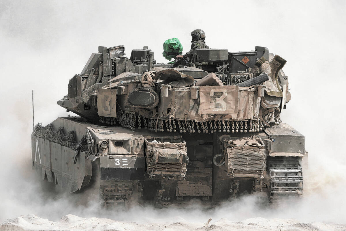Israeli soldiers move tanks around staging area near the border with the Gaza Strip, in souther ...