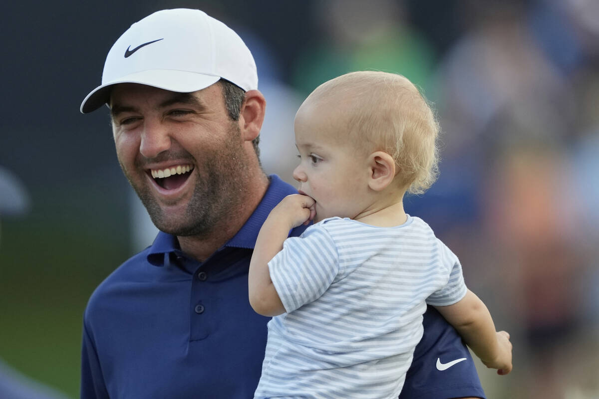 Scottie Scheffler, holds his son Bennett after winning the PGA Championship golf tournament at ...