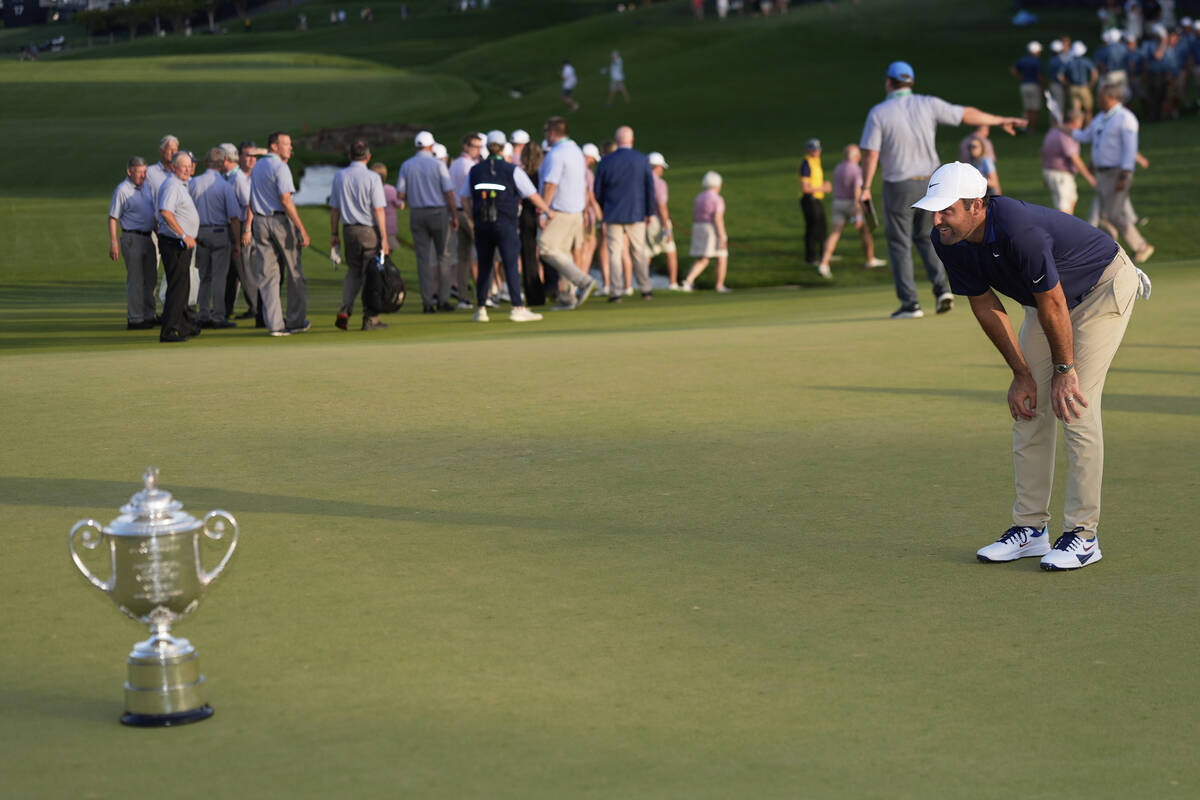 Scottie Scheffler looks at the Wanamaker trophy after winning the PGA Championship golf tournam ...